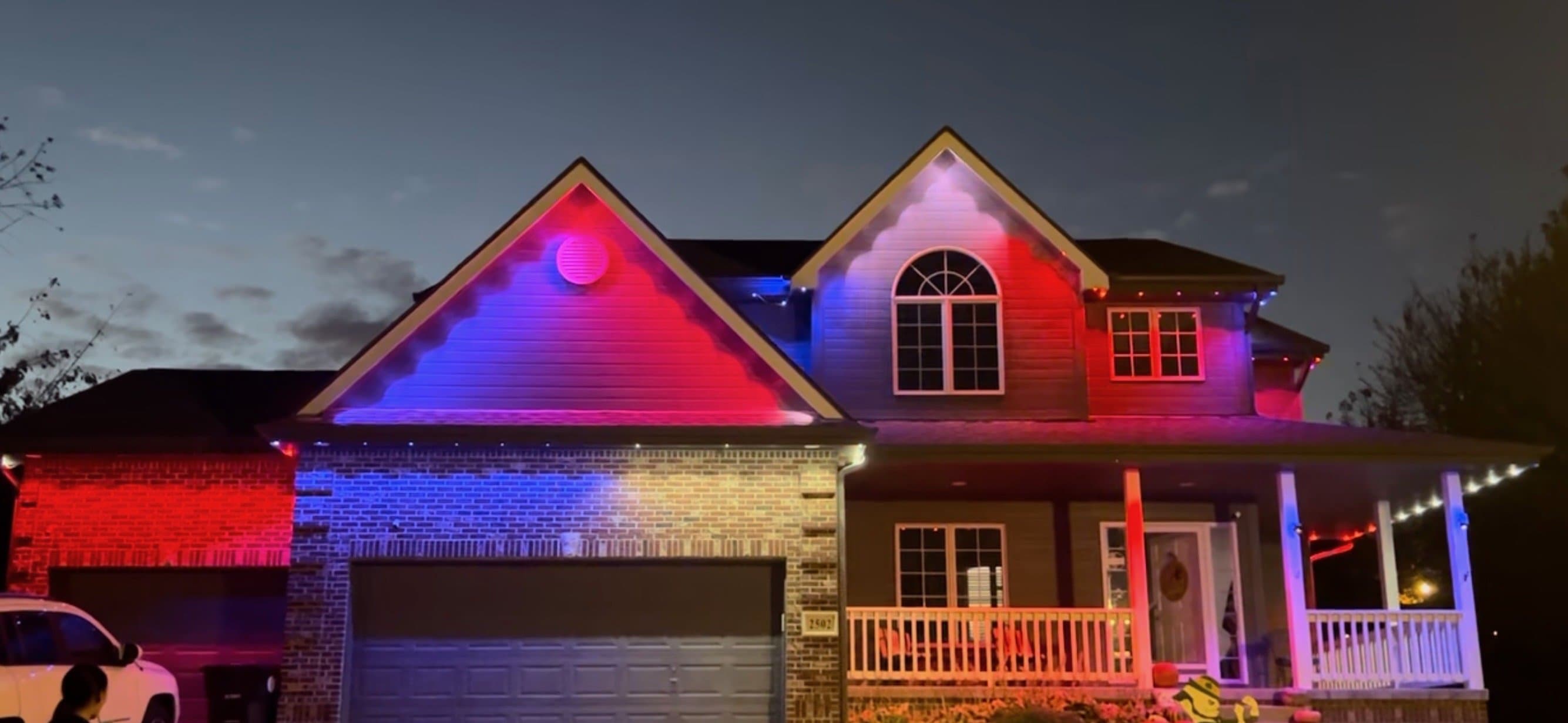 Two story home washed in red, white and blue permanent lighting
